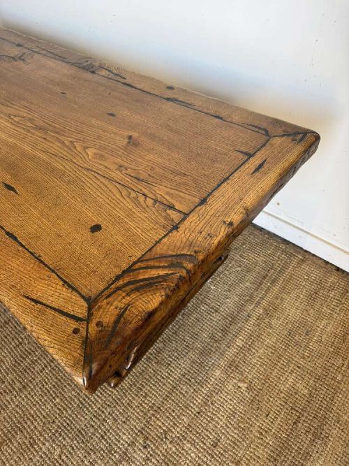 An early 20th-century oak refectory dining table featuring a rectangular framed plank top supported by turned legs on a trestle base with a stretcher rail. View IV