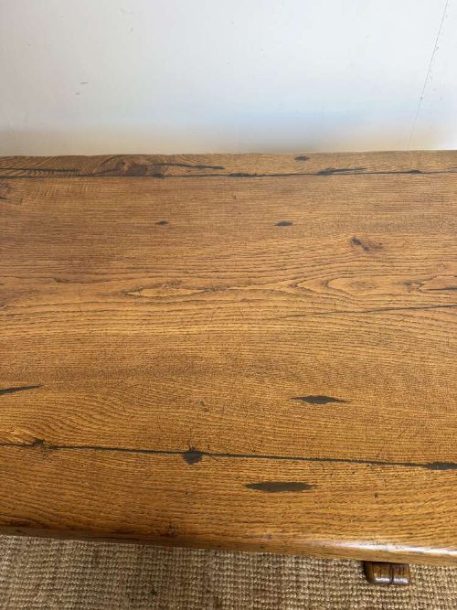 An early 20th-century oak refectory dining table featuring a rectangular framed plank top supported by turned legs on a trestle base with a stretcher rail. View VII