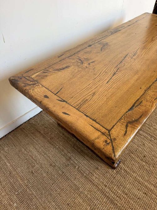 An early 20th-century oak refectory dining table featuring a rectangular framed plank top supported by turned legs on a trestle base with a stretcher rail. View X
