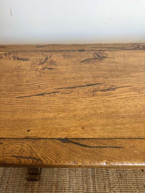 An early 20th-century oak refectory dining table featuring a rectangular framed plank top supported by turned legs on a trestle base with a stretcher rail. View XI