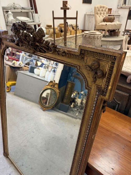 A large 19th-century French Louis Philippe rectangular mirror featuring a gilded frame with rounded top corners, beaded inner moulding, and an ornate floral crest at the top centre. View II