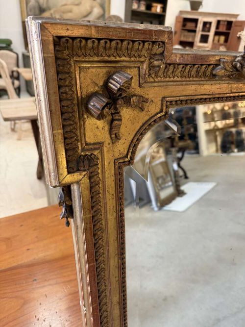 A large 19th-century French Louis Philippe rectangular mirror featuring a gilded frame with rounded top corners, beaded inner moulding, and an ornate floral crest at the top centre. View VI