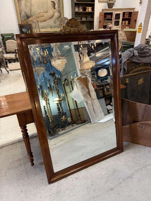 A large rectangular mahogany wall mirror featuring a moulded timber frame and a carved ormolu foliate cresting at the top. View VII