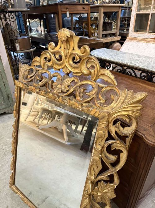 A 19th-century French carved giltwood frame featuring intricate scrollwork, openwork cresting, and a bevelled glass mirror plate. View II