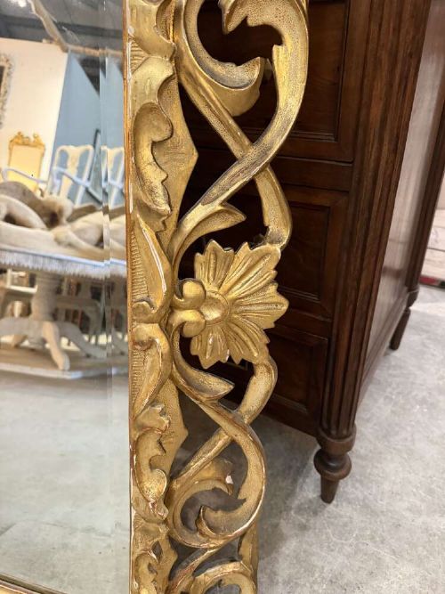 A 19th-century French carved giltwood frame featuring intricate scrollwork, openwork cresting, and a bevelled glass mirror plate. View IV