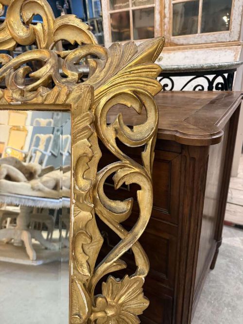 A 19th-century French carved giltwood frame featuring intricate scrollwork, openwork cresting, and a bevelled glass mirror plate. View V