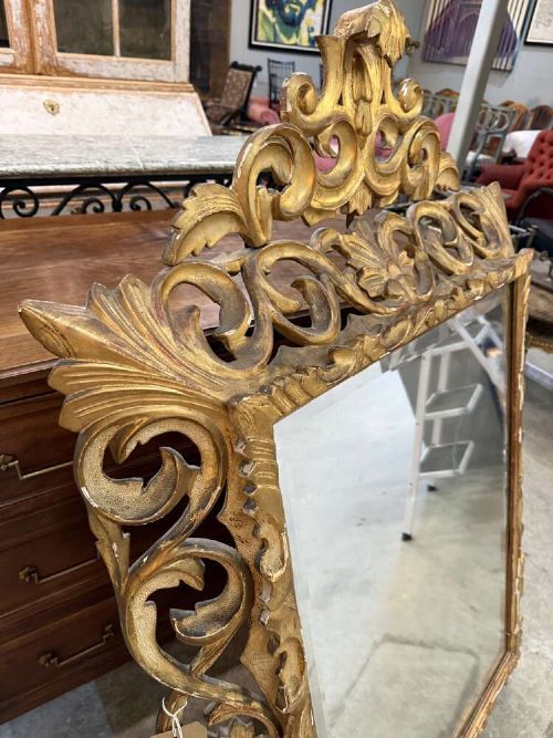 A 19th-century French carved giltwood frame featuring intricate scrollwork, openwork cresting, and a bevelled glass mirror plate. View VI
