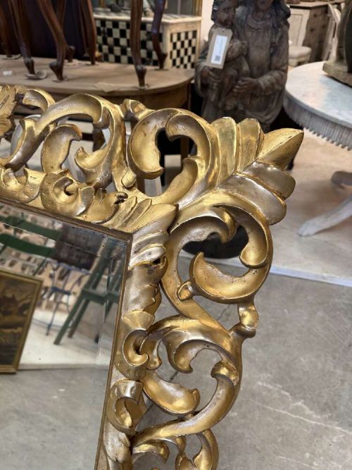 A rectangular mid-19th century French mirror featuring an elaborate, pierced carved gilded wood frame decorated with acanthus leaves and scrollwork. View II