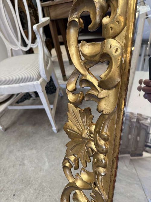 A rectangular mid-19th century French mirror featuring an elaborate, pierced carved gilded wood frame decorated with acanthus leaves and scrollwork. View VI