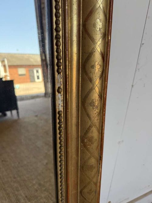A late nineteenth-century French rectangular wall mirror featuring rounded upper corners, an incised gold gilt frame, and a beaded inner border. View IV