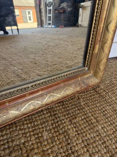 A late nineteenth-century French rectangular wall mirror featuring rounded upper corners, an incised gold gilt frame, and a beaded inner border. View VI