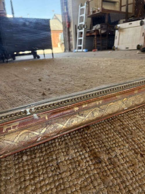 A late nineteenth-century French rectangular wall mirror featuring rounded upper corners, an incised gold gilt frame, and a beaded inner border. View VIII