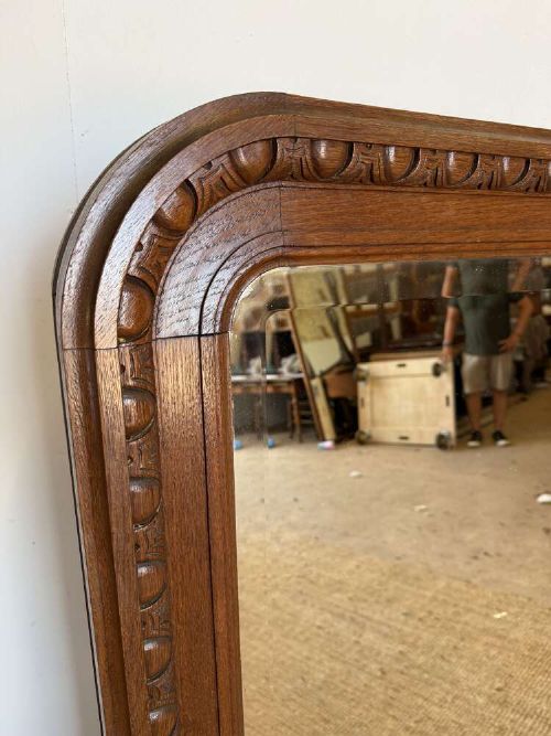 A late 19th-century French carved oak wall mirror with rounded top corners and detailed carved egg and dart moulding along the frame. View II
