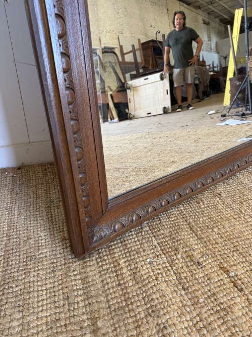 A late 19th-century French carved oak wall mirror with rounded top corners and detailed carved egg and dart moulding along the frame. View IV