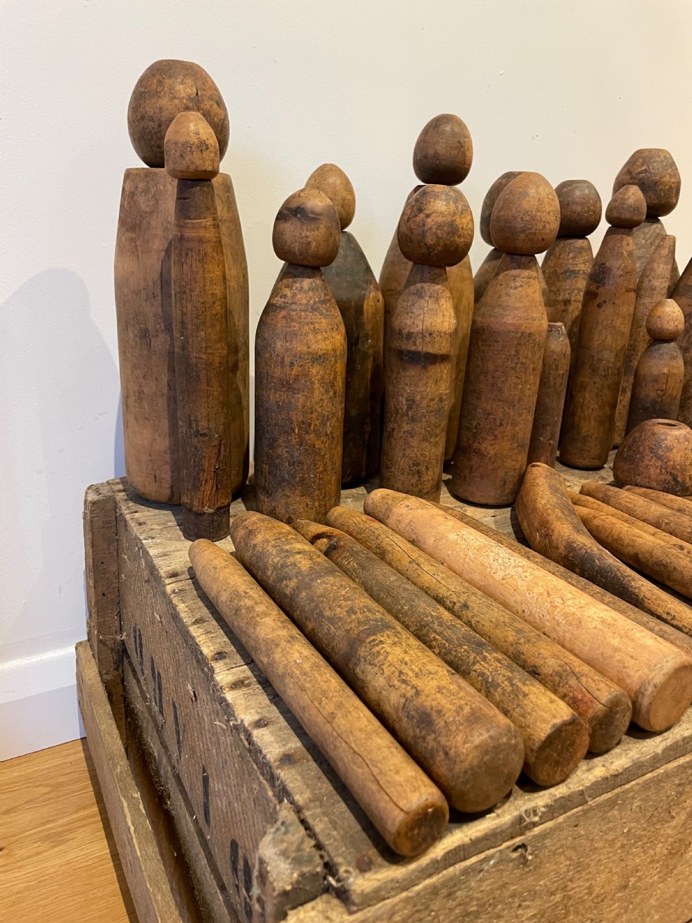 A collection of assorted vintage wooden plumbers turpins, dressers, and cylindrical tools arranged on a wooden surface. View IV