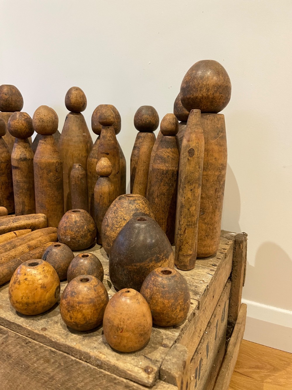 A collection of assorted vintage wooden plumbers turpins, dressers, and cylindrical tools arranged on a wooden surface. View VII