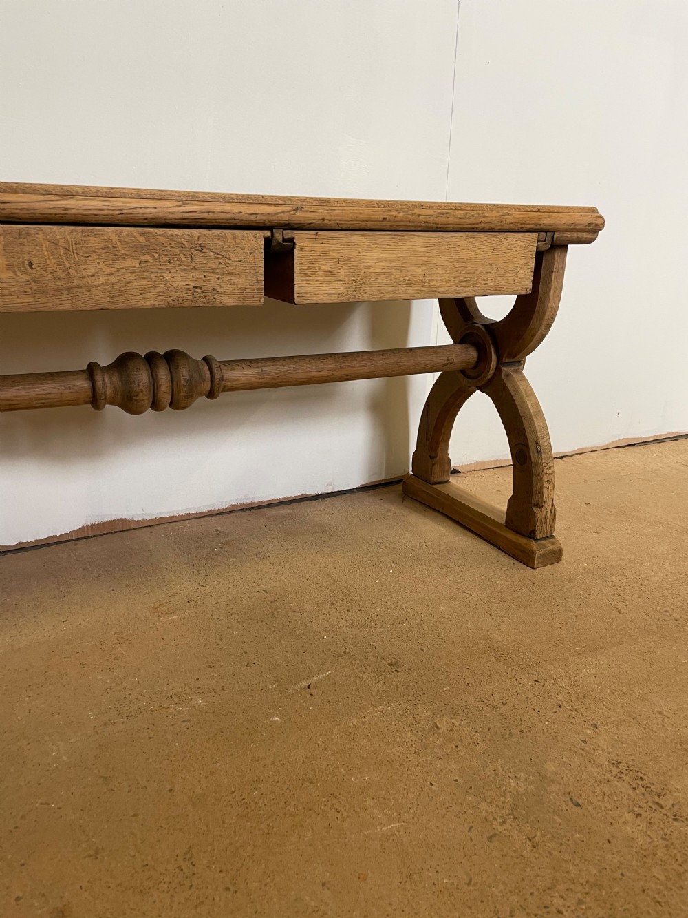 A Victorian oak window seat featuring arched Gothic Revival end legs, two frieze drawers, and a central turned stretcher. View V