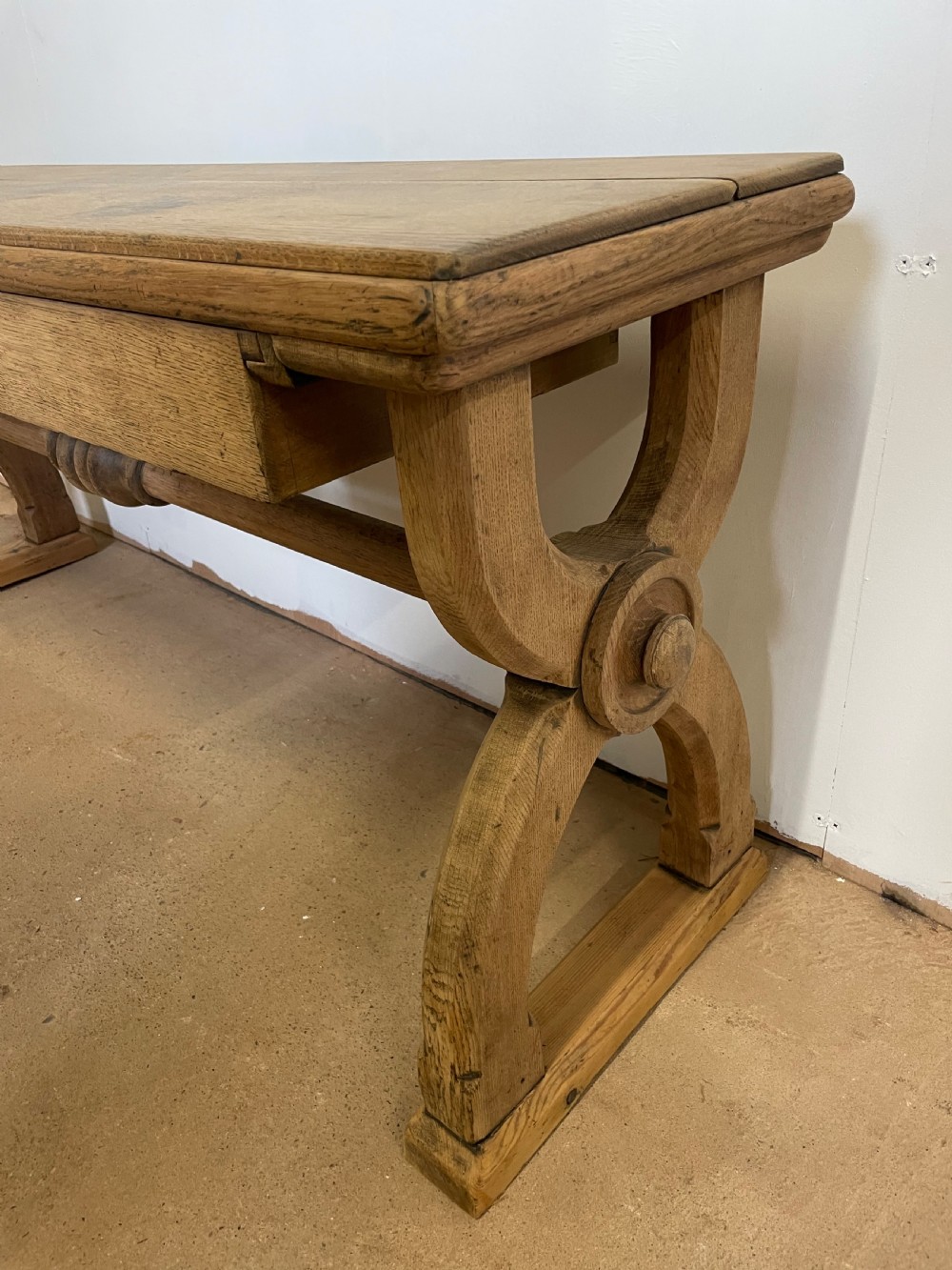 A Victorian oak window seat featuring arched Gothic Revival end legs, two frieze drawers, and a central turned stretcher. View VII