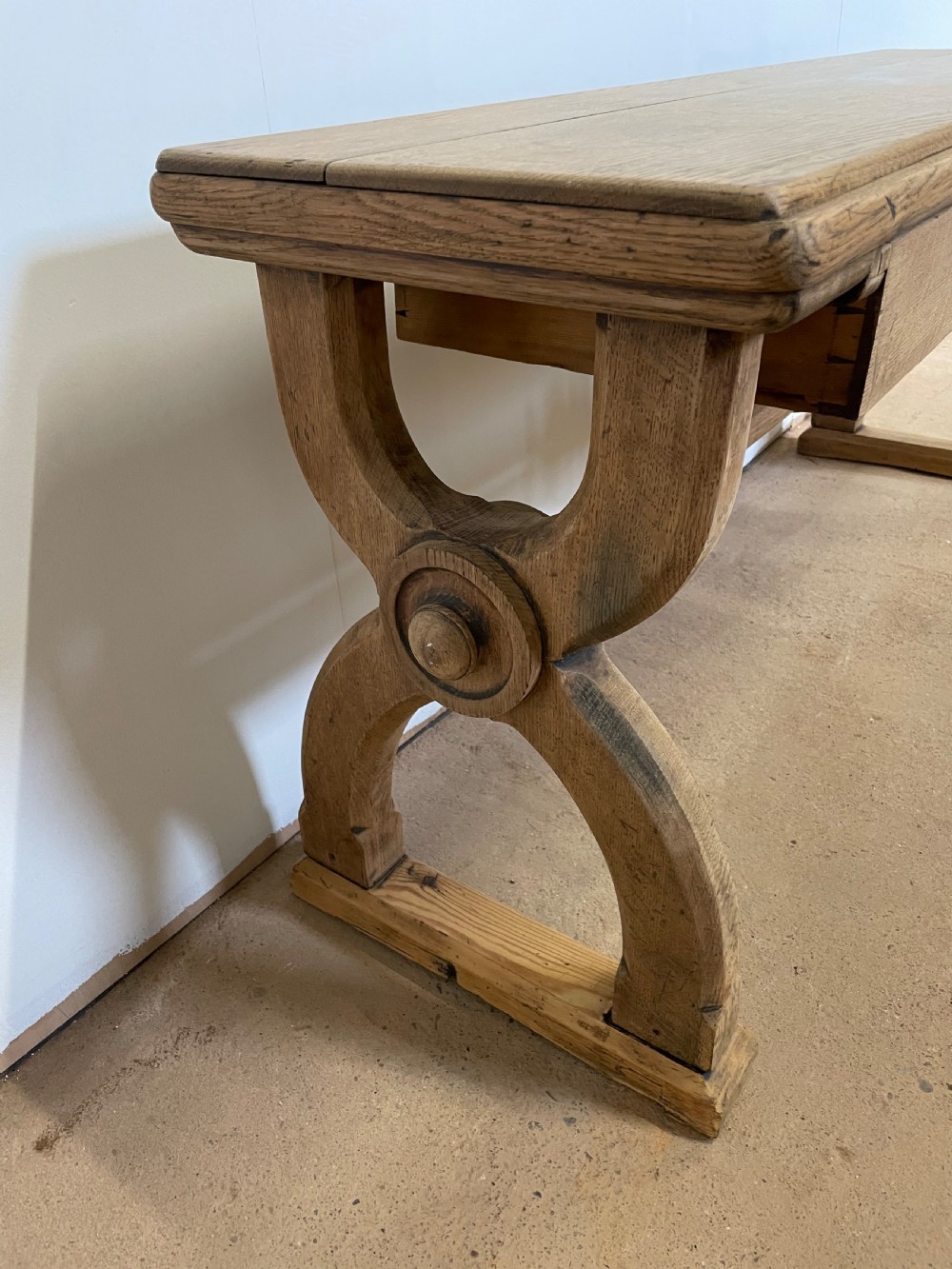 A Victorian oak window seat featuring arched Gothic Revival end legs, two frieze drawers, and a central turned stretcher. View X