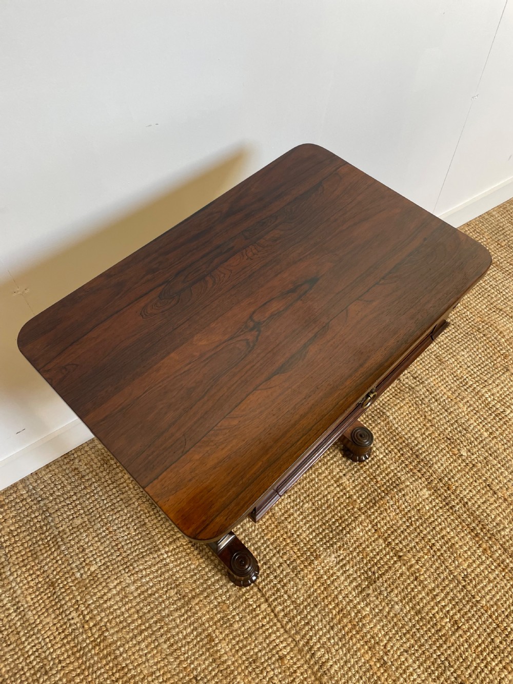A Victorian rosewood work table featuring a single drawer with a brass ring handle, carved side brackets, and an upholstered fabric well beneath. View III
