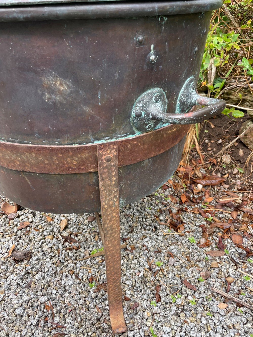 A large lidded copper log bin featuring riveted side handles, a flat lid with a central handle, and a raised iron support stand. View IV