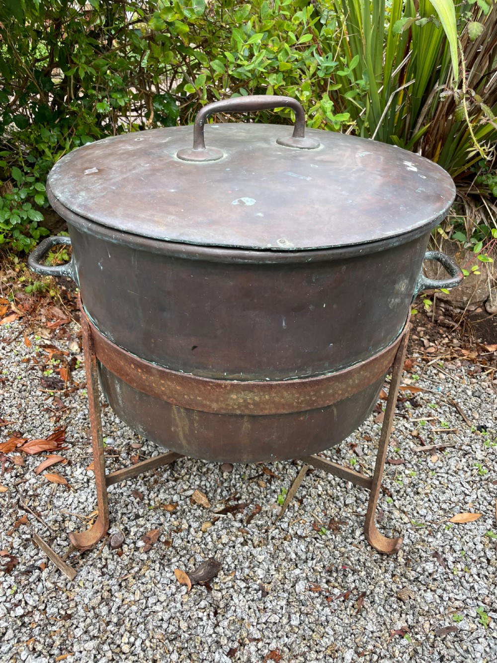 A large lidded copper log bin featuring riveted side handles, a flat lid with a central handle, and a raised iron support stand. View VIII