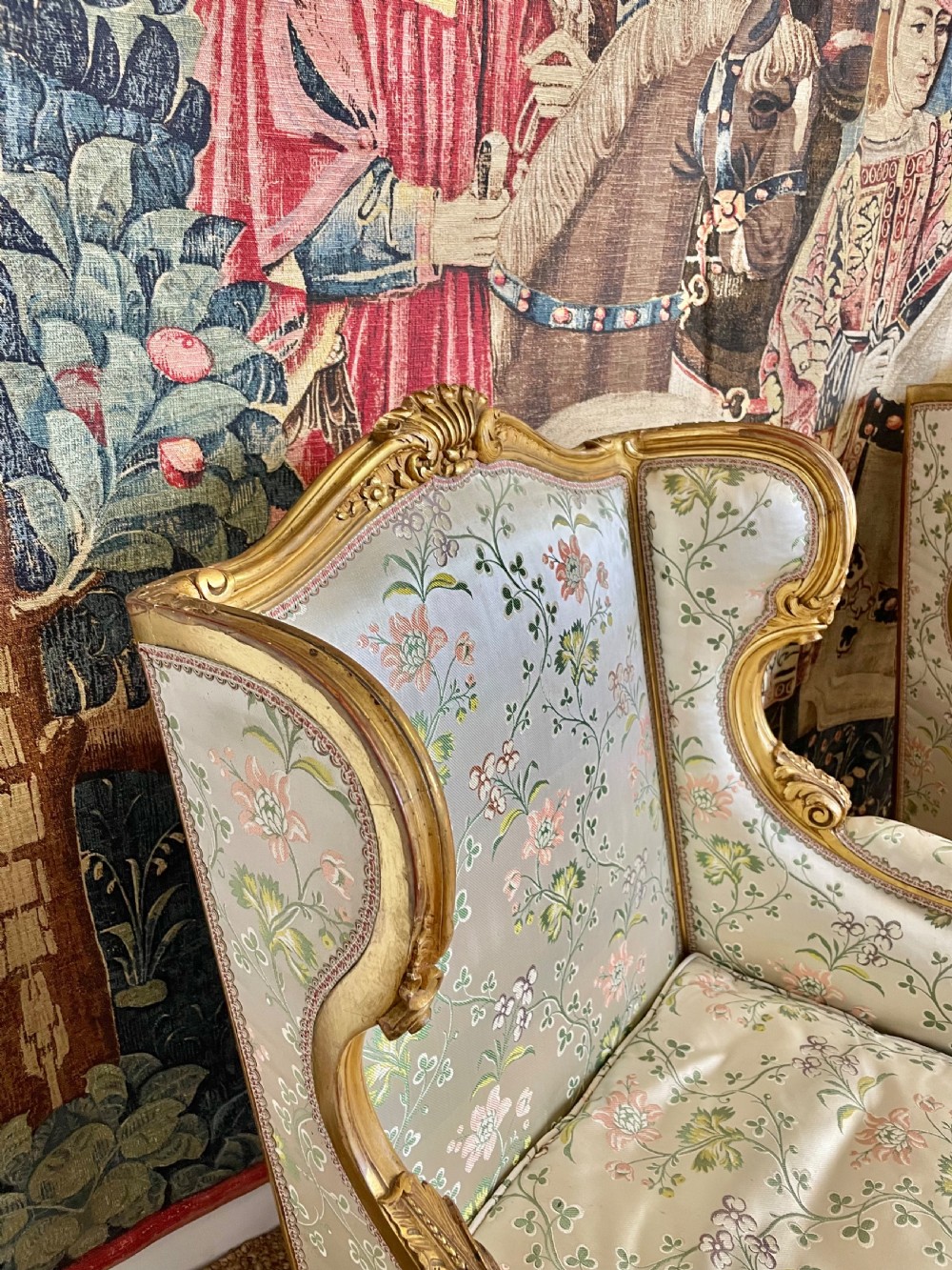 A pair of carved gilt wood fauteuil armchairs upholstered in patterned floral silk fabric. View V