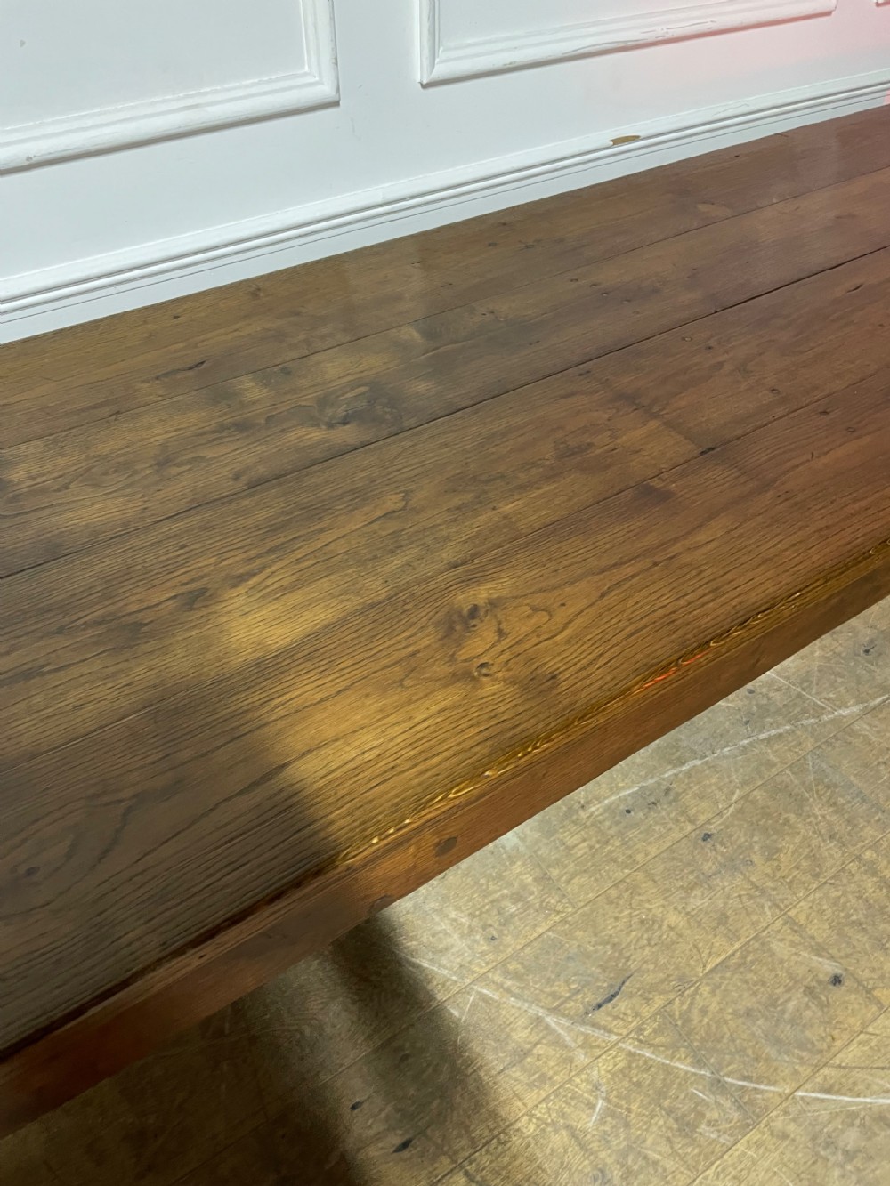A long, antique oak farmhouse dining table featuring a planked timber top and straight wooden legs joined by side stretchers. View IV
