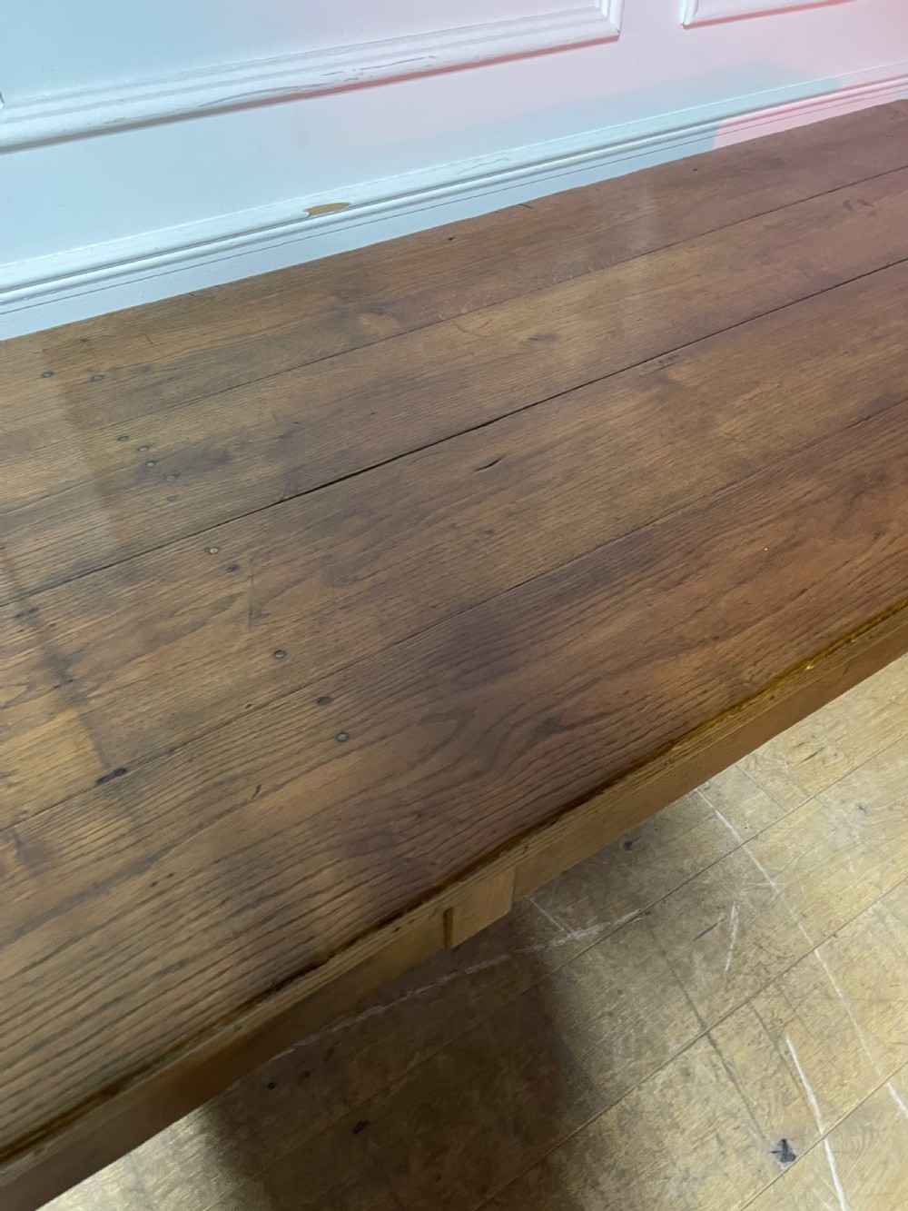 A long, antique oak farmhouse dining table featuring a planked timber top and straight wooden legs joined by side stretchers. View V