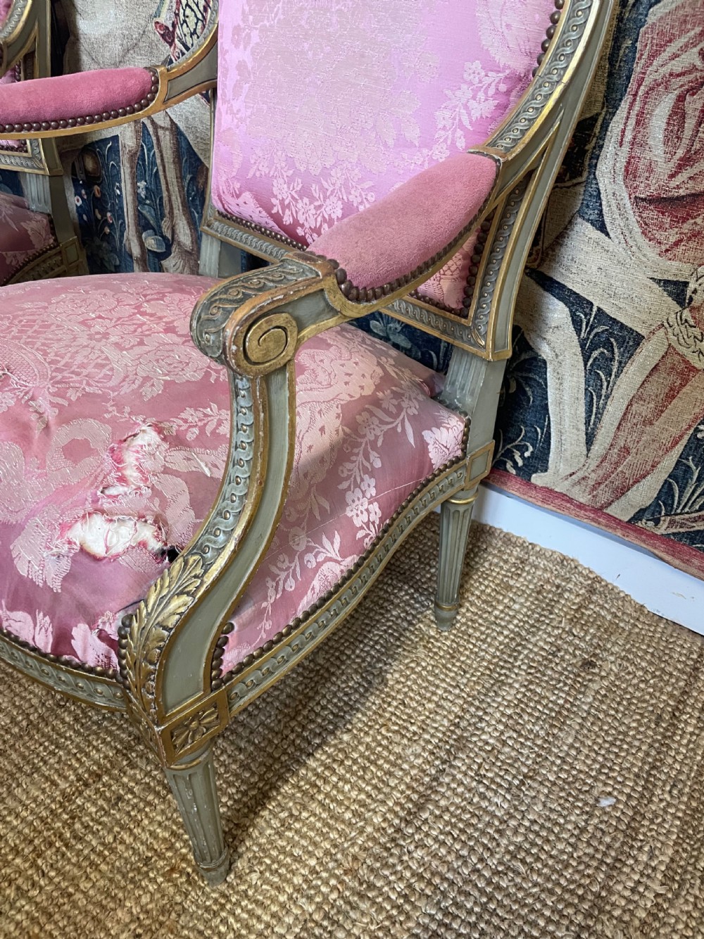 A pair of antique French fauteuils featuring carved gilt frames and pink patterned silk upholstery. View IV