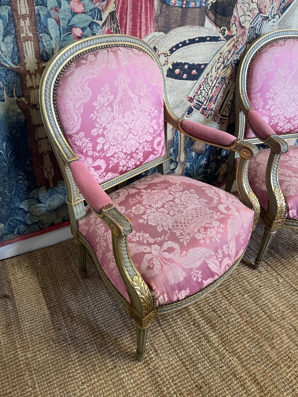 A pair of antique French fauteuils featuring carved gilt frames and pink patterned silk upholstery. View VI