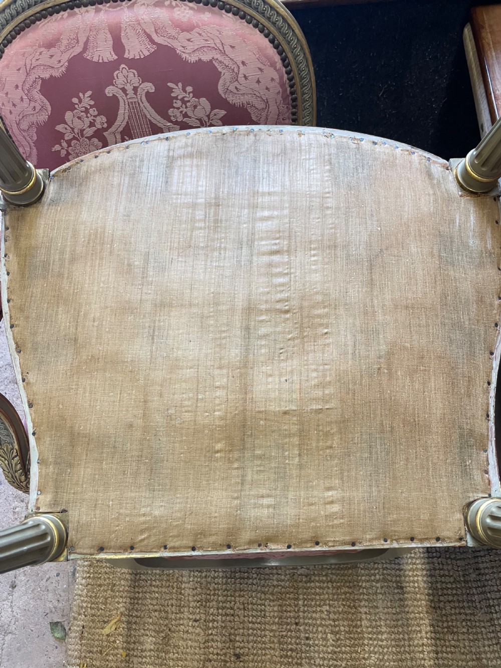 A pair of antique French fauteuils featuring carved gilt frames and pink patterned silk upholstery. View IX