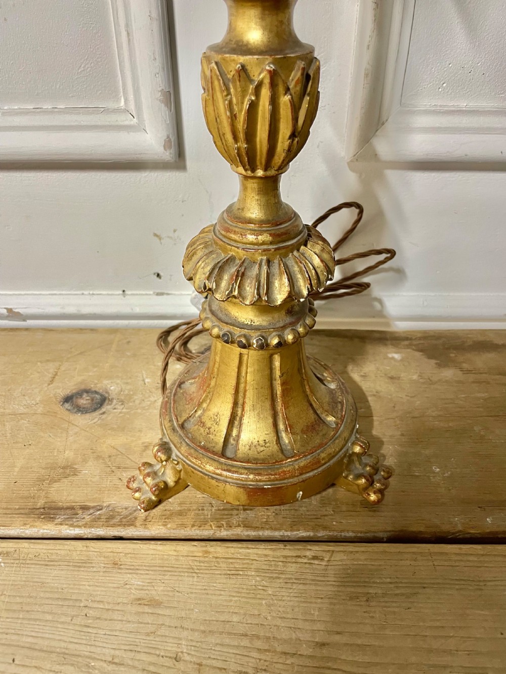 A tall Italian giltwood table lamp styled as a candlestick with acanthus leaf carvings, a fluted stem, and a faux candle sleeve. View II