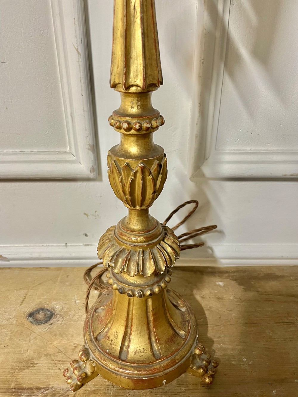 A tall Italian giltwood table lamp styled as a candlestick with acanthus leaf carvings, a fluted stem, and a faux candle sleeve. View III