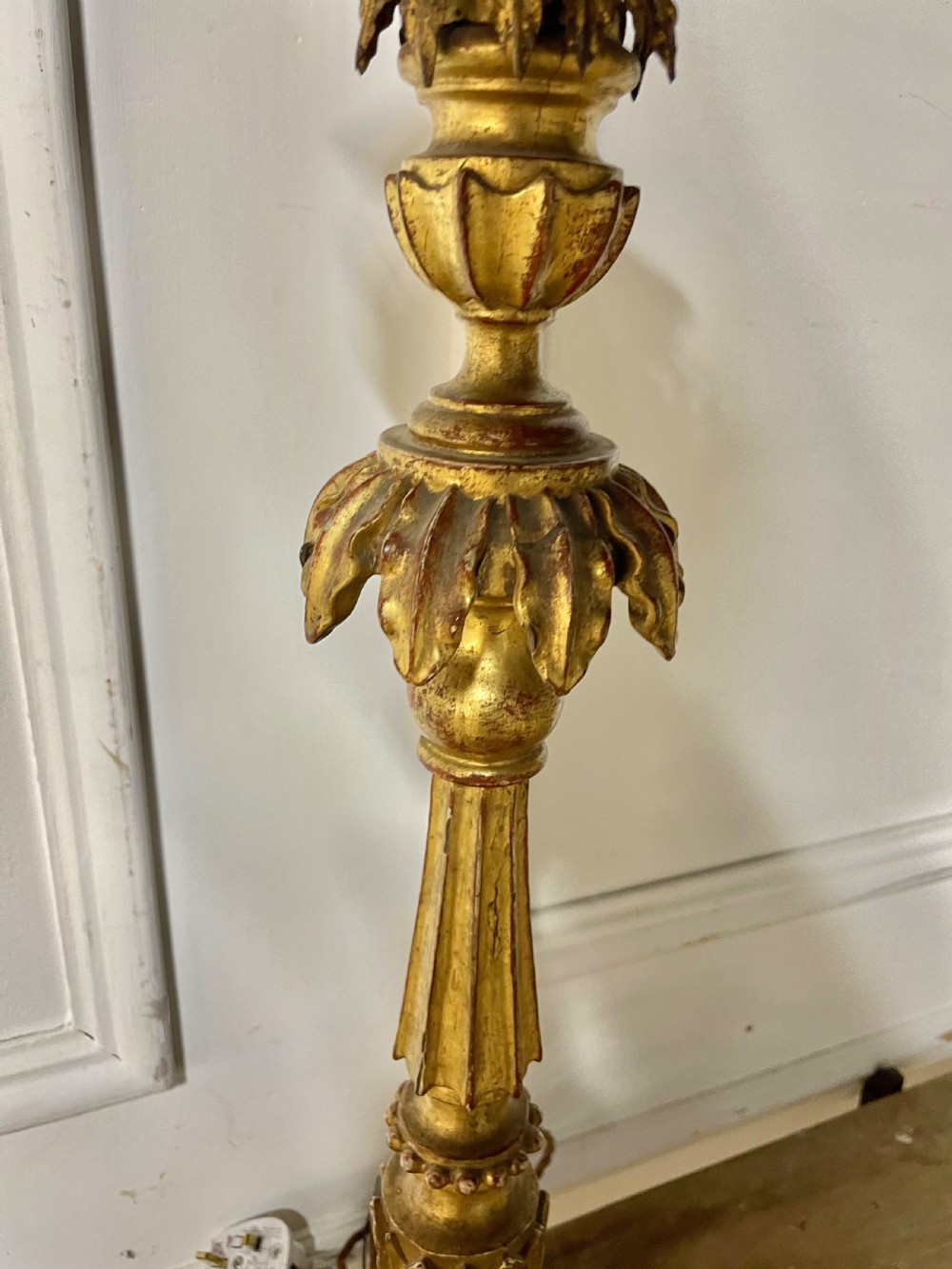 A tall Italian giltwood table lamp styled as a candlestick with acanthus leaf carvings, a fluted stem, and a faux candle sleeve. View VI