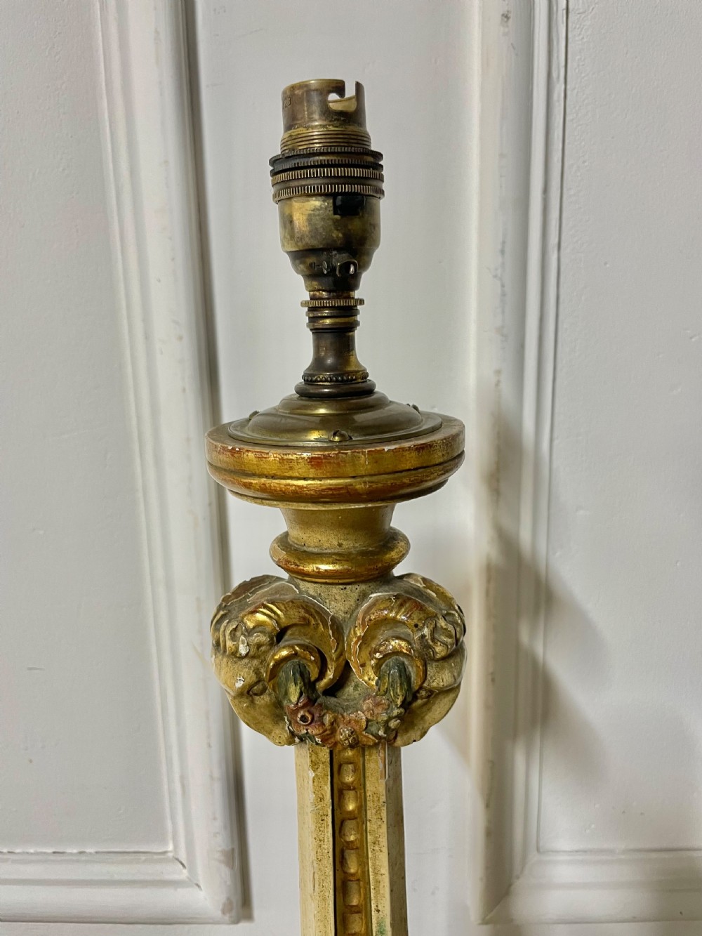 A tall, carved giltwood and cream painted table lamp base featuring neoclassical scrollwork and floral swags. View II