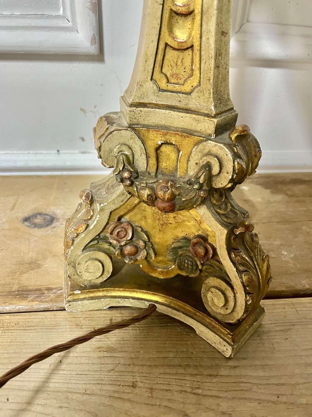 A tall, carved giltwood and cream painted table lamp base featuring neoclassical scrollwork and floral swags. View VIII