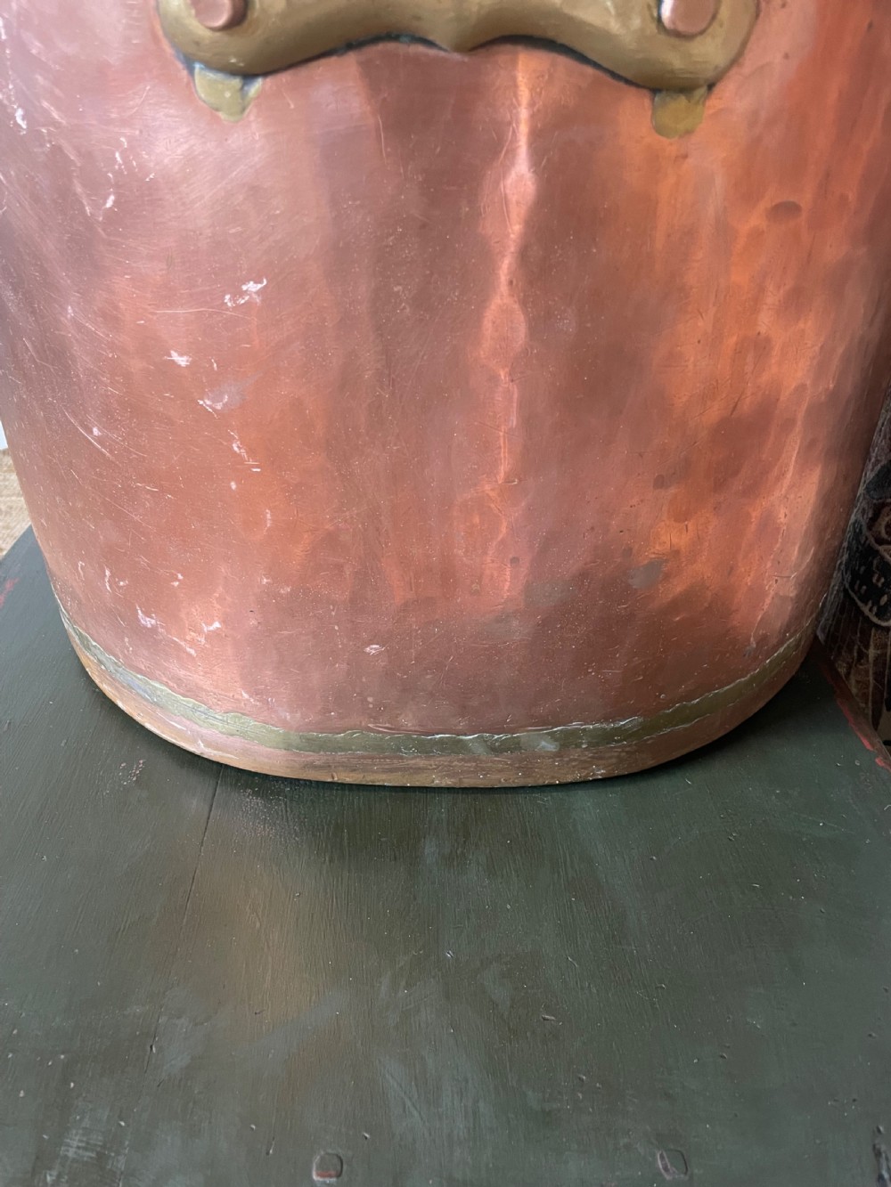 A large cylindrical copper log bin featuring two cast brass side handles and a hammered metal finish. View IV