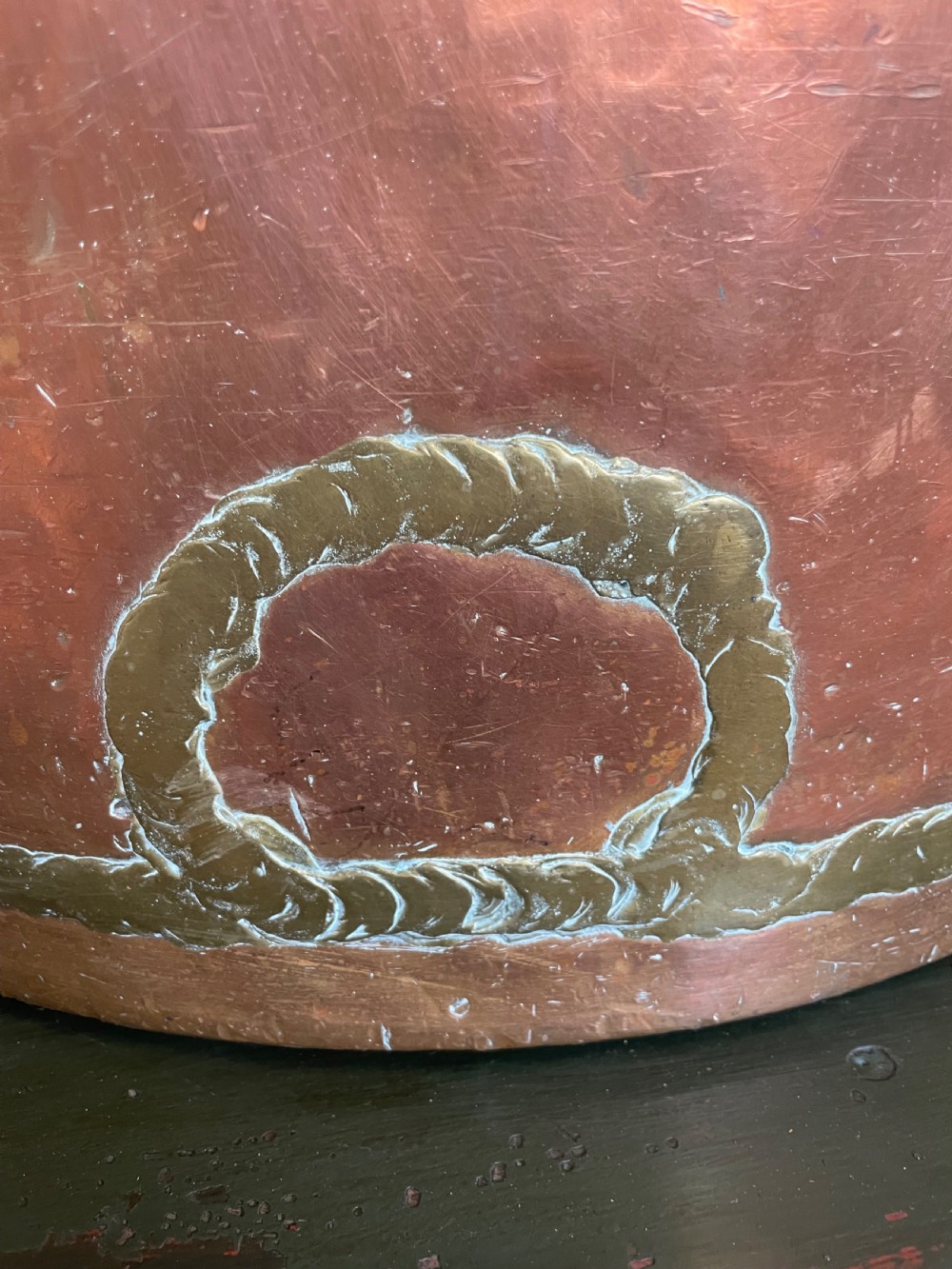 A large cylindrical copper log bin featuring two cast brass side handles and a hammered metal finish. View VIII
