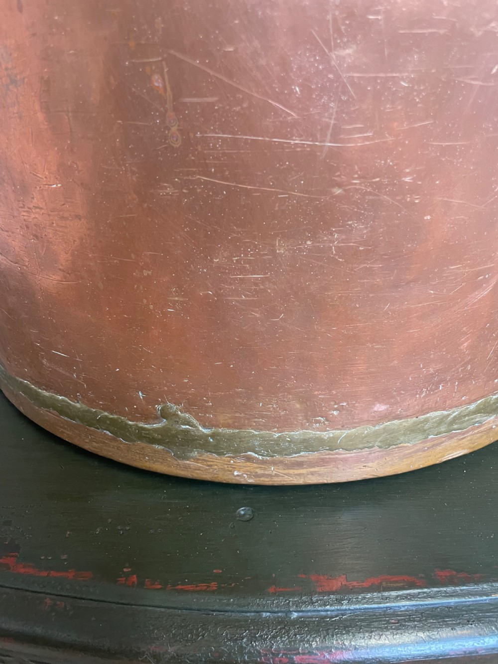 A large cylindrical copper log bin featuring two cast brass side handles and a hammered metal finish. View X