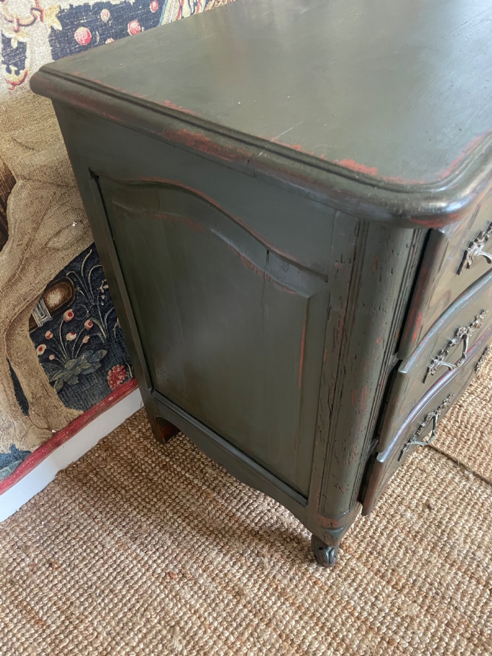A dark green painted French commode chest of drawers featuring moulded panels, distressed finish, and decorative brass handles. View II