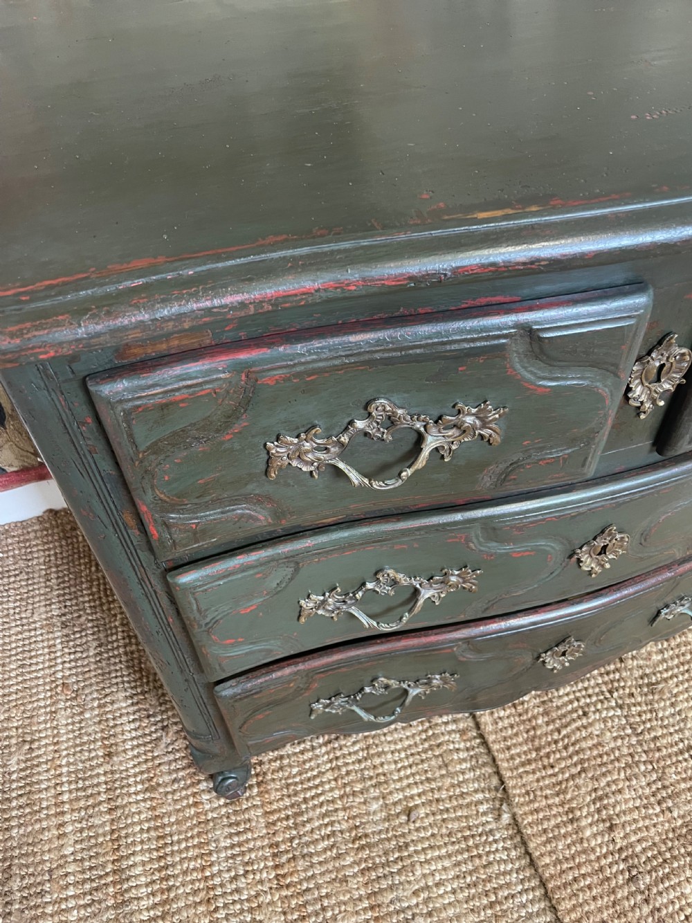A dark green painted French commode chest of drawers featuring moulded panels, distressed finish, and decorative brass handles. View VI