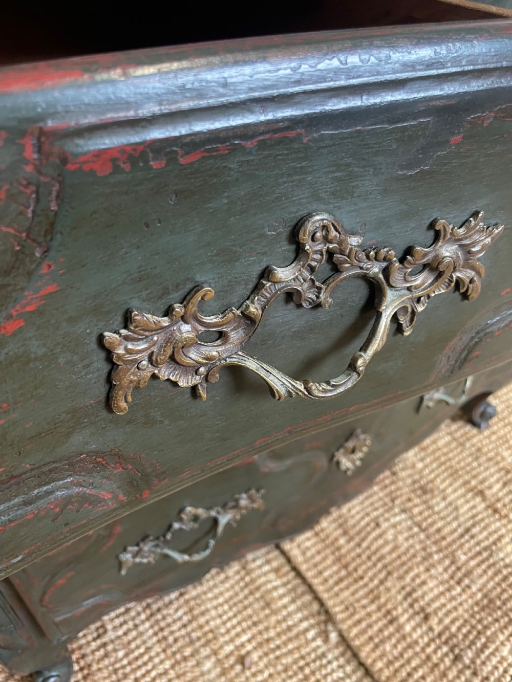 A dark green painted French commode chest of drawers featuring moulded panels, distressed finish, and decorative brass handles. View VII