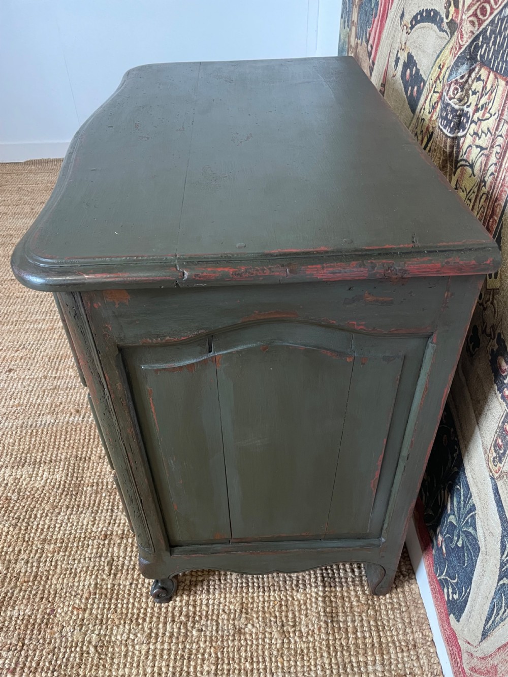 A dark green painted French commode chest of drawers featuring moulded panels, distressed finish, and decorative brass handles. View X