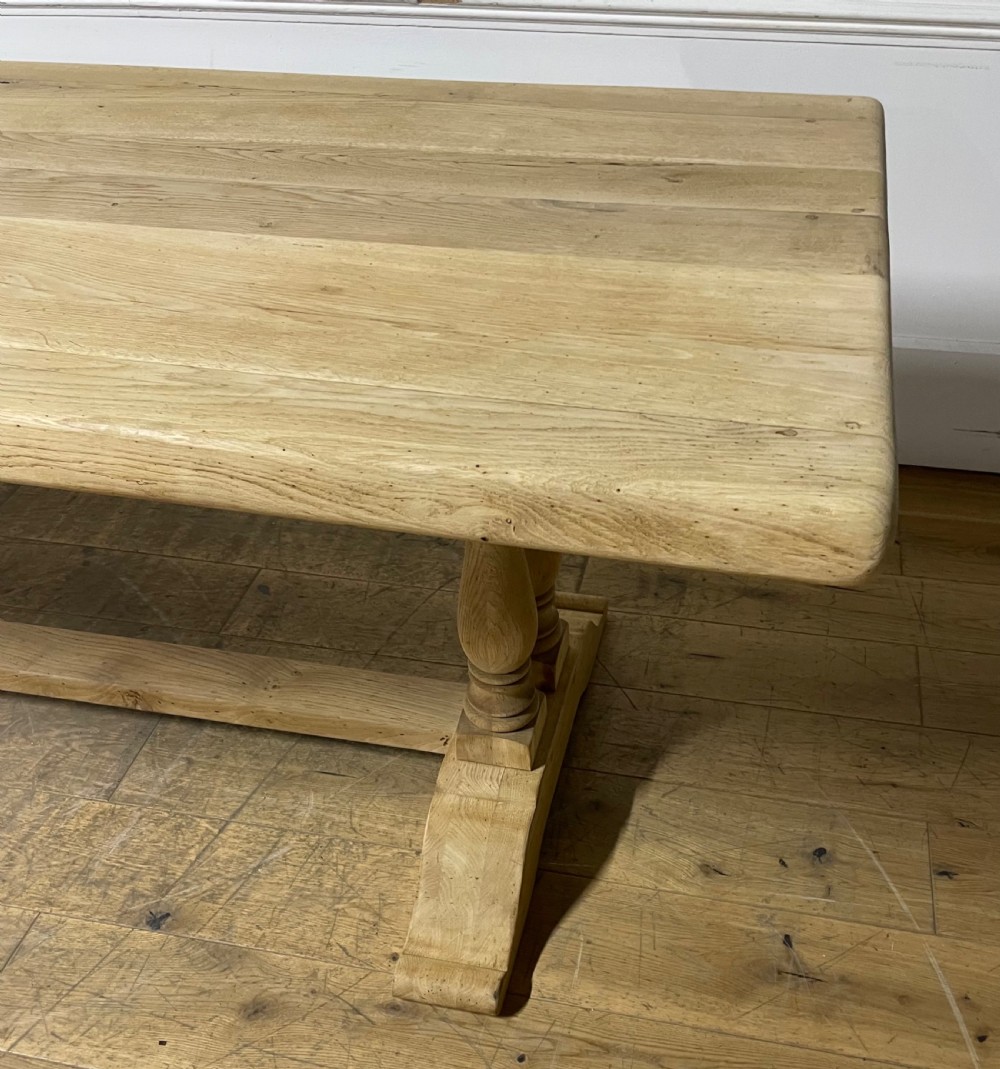 A long rectangular scrubbed oak refectory table featuring turned pedestal supports and a central stretcher. View II