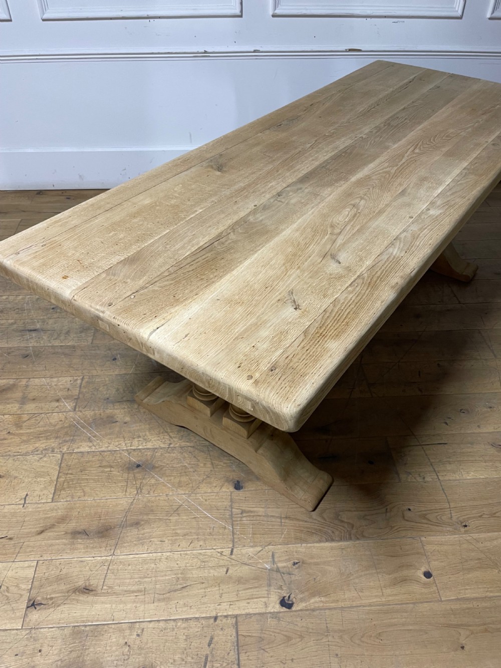 A long rectangular scrubbed oak refectory table featuring turned pedestal supports and a central stretcher. View VII
