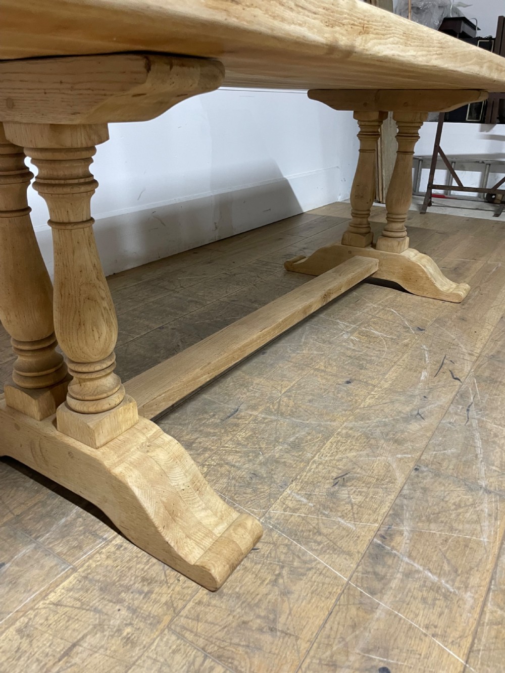 A long rectangular scrubbed oak refectory table featuring turned pedestal supports and a central stretcher. View IX