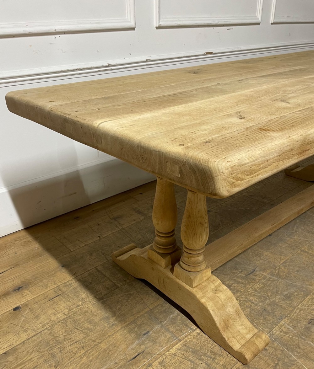 A long rectangular scrubbed oak refectory table featuring turned pedestal supports and a central stretcher. View XI