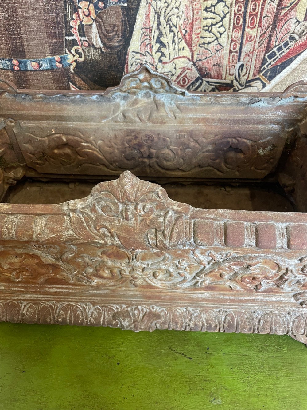 A rectangular cast iron planter trough featuring ornate relief scrollwork, foliate motifs, and a weathered rust patina. View IV