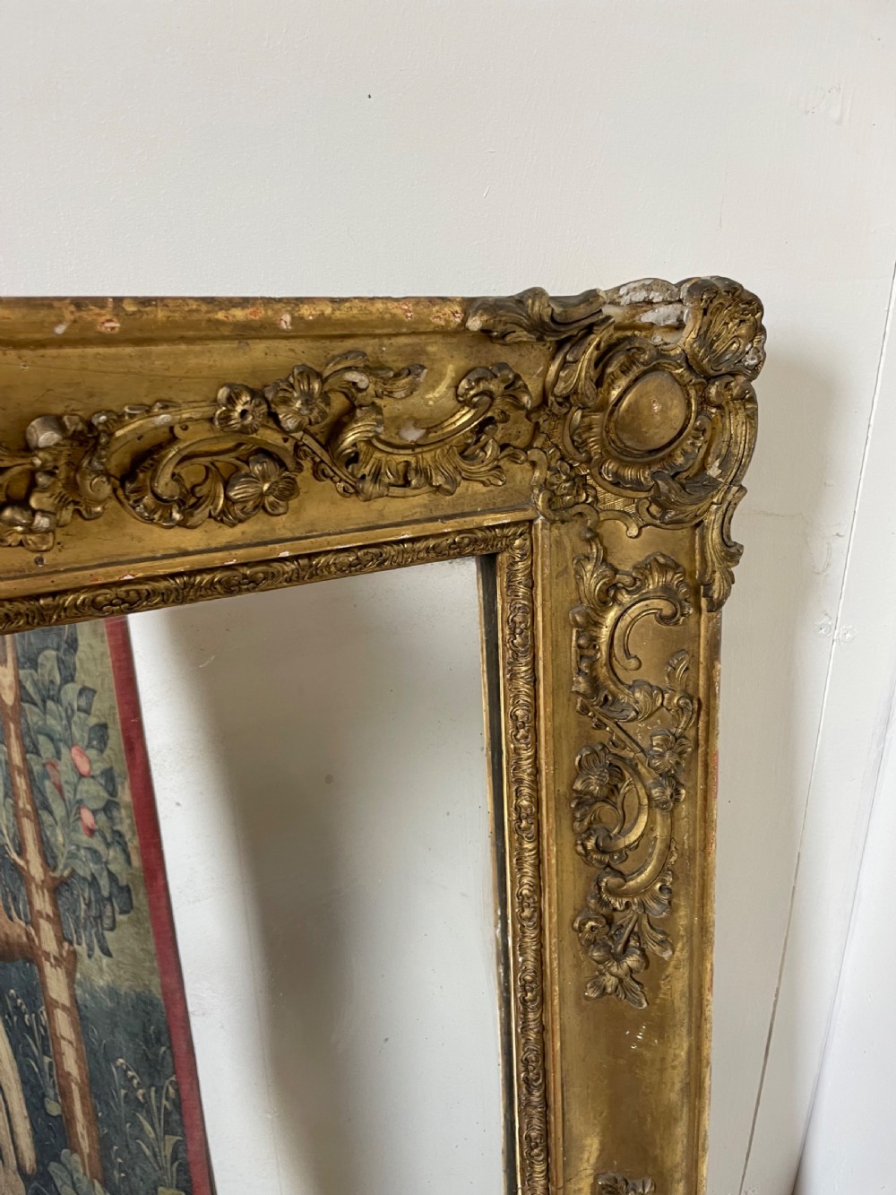 A large early 19th-century rectangular overmantle mirror with a detailed gold leaf frame featuring carved acanthus motifs and a central crest. View V